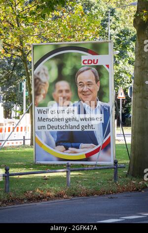 Wiesbaden, Deutschland - 25. August 2021: Wahlkampfplakat der Christlich Demokratische Union (CDU) in der Innenstadt von Wiesbaden, Hessen. Die Christlich-Demokratische Union (CDU) ist eine christdemokratische und liberal-konservative Partei in Deutschland und wird von Armin Laschet angeführt. Deutschland steht am 26. September vor Bundestagswahlen. Einige Verkehrsteilnehmer im Hintergrund Stockfoto