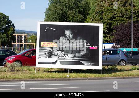 Wiesbaden, 25. August 2021: Wahlkampfplakat der Freien Demokratischen Partei (FDP) in der Innenstadt von Wiesbaden, Hessen. Die Freie Demokratische Partei (FDP) ist eine klassisch-liberale politische Partei in Deutschland. Die FDP wird von Christian Lindner geleitet. Deutschland steht am 26. September vor Bundestagswahlen. Einige Verkehrsteilnehmer im Hintergrund Stockfoto