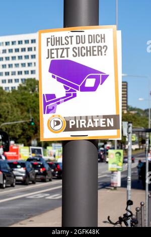 Wiesbaden, Deutschland - 25. August 2021: Wahlkampfplakat der Deutschen Partei Piraten in der Innenstadt von Wiesbaden, Hessen. Die Piratenpartei ist Teil der internationalen Bewegung der Piratenparteien und Mitglied der Piratenpartei International. Deutschland steht am 26. September vor Bundestagswahlen. Einige Verkehrsteilnehmer im Hintergrund Stockfoto