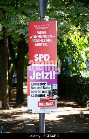 Wiesbaden, 25. August 2021: Wahlkampfplakate der Partei DIE linke und der Sozialdemokratischen Partei (SPD) im Stadtzentrum von Wiesbaden, Hessen. Deutschland steht am 26. September vor Bundestagswahlen. Einige Verkehrsteilnehmer im Hintergrund Stockfoto