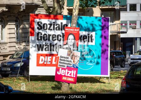 Wiesbaden, 25. August 2021: Wahlkampfplakate der Partei DIE linke und der Sozialdemokratischen Partei (SPD) im Stadtzentrum von Wiesbaden, Hessen. Deutschland steht am 26. September vor Bundestagswahlen. Einige Verkehrsteilnehmer im Hintergrund Stockfoto