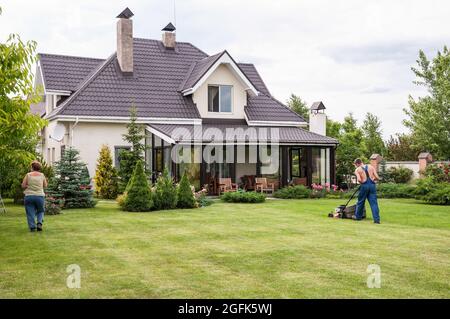 Menschen, die an einem sonnigen Tag ein Privathaus im Garten arbeiten Stockfoto