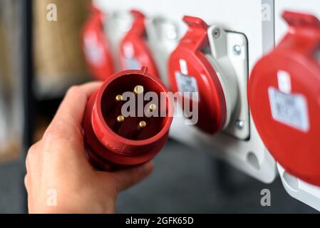 Industriesteckdosen und Stecker auf der Verteilerplatine. Baustelle Strom, temporäre Energieversorgung Stockfoto