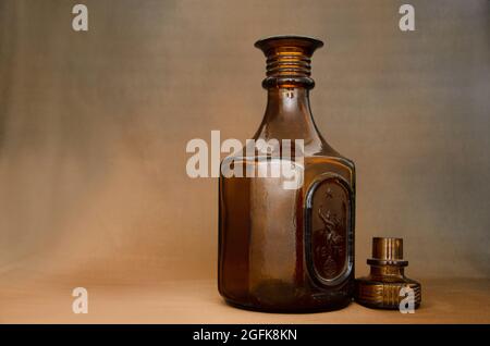 Leere braune Glasflasche auf braunem Hintergrund Stockfoto