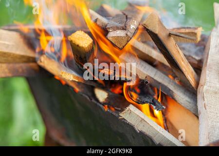 Das Feuerholz im Grill brennt mit einer leuchtend orangefarbenen Feuerflamme Stockfoto