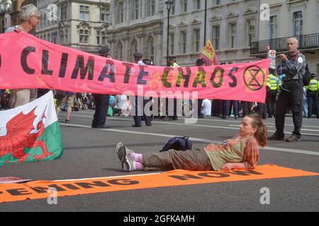 Während der Demonstration saßen Demonstranten auf dem Boden und blockierten die Straße. Klimaaktivisten von Extinction Rebellion. Stockfoto