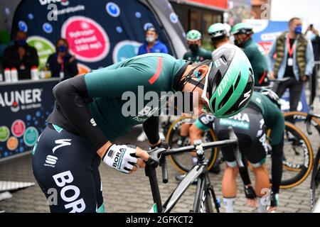 Stralsund, Deutschland. August 2021. Radsport: Deutschland-Rundfahrt, Etappe 1, Stralsund - Schwerin. Emanuel Buchmann, Team Bora-hansgrohe, inspiziert den Sattel vor dem Start. Quelle: Bernd Thissen/dpa/Alamy Live News Stockfoto