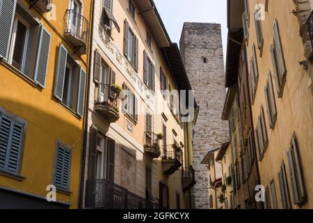 Citta Alta, Bergamo, Italien: Typische Straßenszene; Palazzos mit versperrten Fenstern; schmale, geschwungene Via Gombito; Blick auf den Torre del Gombito. Stockfoto