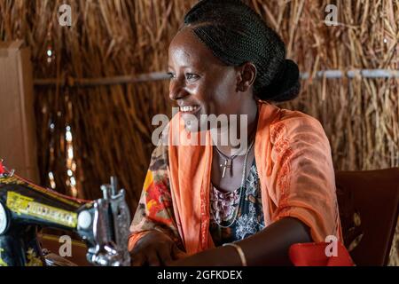 Gedaref, Washington, Sudan. August 2021. YEMAR ABRAHA, Flüchtling aus Tigray, praktiziert das Nähen bei einem von der Norwegischen Kirchenhilfe (NCA) gesponserten Schneiderschulungsprogramm im Flüchtlingslager Tuneidba in der Nähe von Gedaref, Sudan. Bildung im Kindesalter, Ausbildung des Lebensunterhalts, WASH und sichere Räume für Frauen sind nur einige der Anstrengungen, die die NCA im Lager unternommen hat. (Bild: © Gregg Brekke/ZUMA Press Wire) Stockfoto