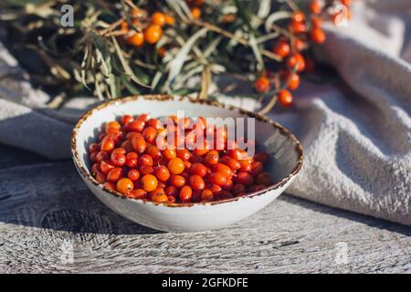 Sanddornbeeren auf dem Teller auf dem hellen Hintergrund, Sanddornöl und die Mors, Sanddorntee. Super Nahrung und gesunde Ernährung Stockfoto