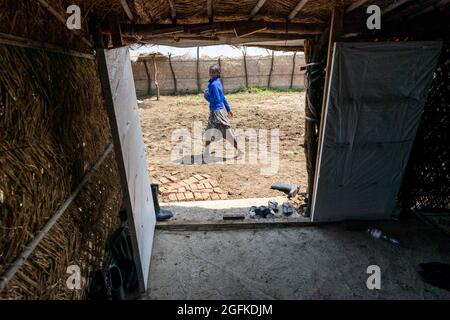 Gedaref, Washington, Sudan. August 2021. Eine Studentin spaziert durch den sicheren Raum für Frauen und Mädchen aus Tigray, der von der norwegischen Kirchenhilfe im Flüchtlingslager Tuneidba in der Nähe von Gedaref im Sudan gesponsert wird. Das Lager beherbergt derzeit 20,000 Menschen, in denen mehrere Gruppen für die Bereitstellung grundlegender Dienste arbeiten. (Bild: © Gregg Brekke/ZUMA Press Wire) Stockfoto