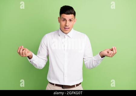 Foto von unglücklich ziemlich jungen Kerl gekleidet weißen Hemd fragen verstehen ihn isoliert grüne Farbe Hintergrund Stockfoto