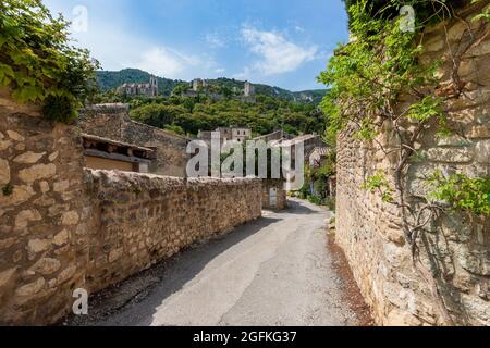 FRANKREICH, LUBERON, VAUCLUSE, 84, OPPEDE-LE-VIEUX, SCHÖNES KLEINES DORF AUF EINEM FELSIGEN AUSBISS ÜBERWUCHERT VEGETATION MIT EINER HERRLICHEN KULISSE GEBAUT, EIN Stockfoto