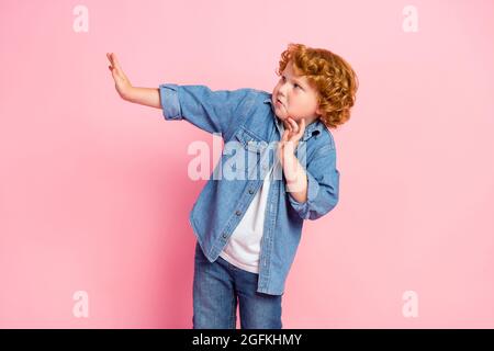 Foto von Angst nervös kleinen Jungen suchen leeren Raum Vermeiden Bully tragen Denim Jacke isoliert rosa Farbe Hintergrund Stockfoto