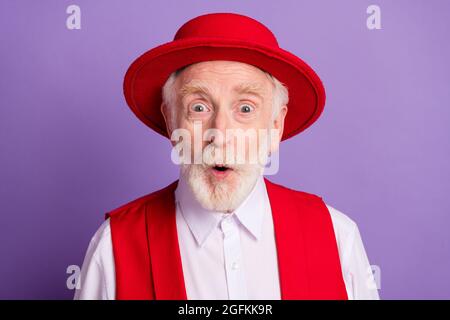 Foto von stauned schockiert glücklich positiven alten Mann tragen Hut beeindruckt Nachrichten isoliert auf violetten Hintergrund Stockfoto