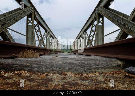 Alte rostige verlassene Eisenbahnbrücke in Perspektive Stockfoto