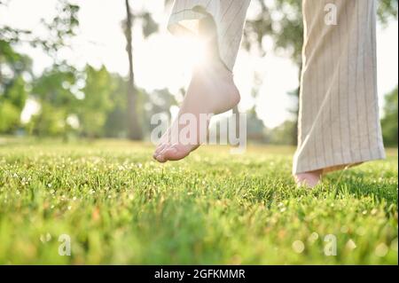 Frau in Hosen barfuß im Park Stockfoto