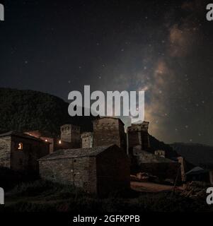 Das Dorf Ushguli mit seinen Verteidigungstürmen in Svaneti, Georgia, bei Nacht mit der Milchstraße und den Sternen. Stockfoto