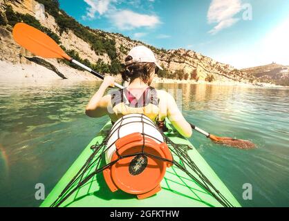 Rückansicht einer Frau, die an sonnigen Tagen auf dem See gegen den Himmel kajak gefahren ist Stockfoto