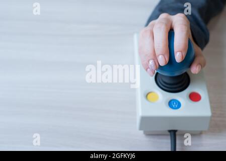 Frau mit zerebraler Lähmung arbeitet an einer spezialisierten Computermaus. Stockfoto