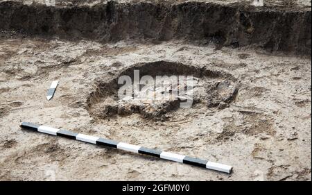 Archäologische Ausgrabungen, Archäologen arbeiten, graben ein altes Tonartefakt mit speziellen Werkzeugen im Boden Stockfoto