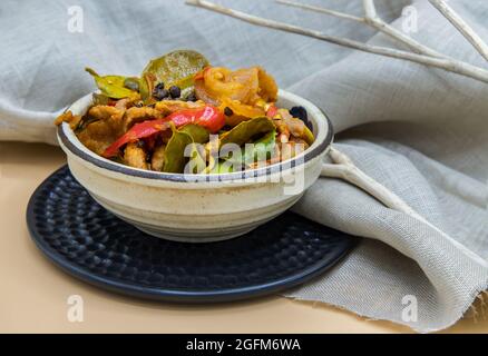 Gebratenes würziges Wildschwein mit rotem Chili in einer weißen Schüssel umrühren. Selektiver Fokus. Stockfoto