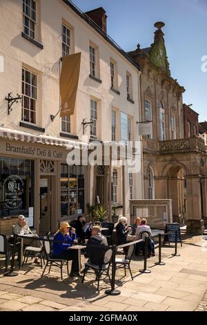 Großbritannien, England, Derbyshire, Ashbourne, Market Place, Costomers außerhalb von Bramhall’s Deli and Coffee Stockfoto