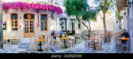 Traditionelle griechische Tavernen und Café auf den Straßen mit alten Männern. Insel iOS, Altstadt Chora.Kykladen, Griechenland 30.05.21 Stockfoto