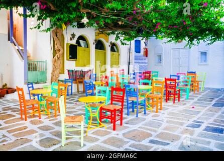 Traditionelle griechische Tavernen auf den Straßen. Insel iOS, Altstadt Chora. Restaurant mit bunten, typischen Stühlen. Kykladen, Griechenland Stockfoto