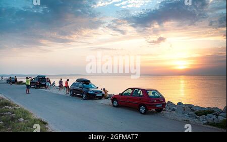 Touristen bewundern den Sonnenuntergang auf der Insel Vir, Kroatien. Stockfoto
