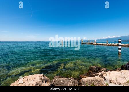 Gardasee (Lago di Garda) vor dem kleinen Hafen von Cisano di Bardolino. Ferienort in der Provinz Verona, Venetien, Italien, Südeuropa. Stockfoto