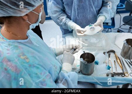 Ein Team von Chirurgen kämpft um das Leben und führt eine komplexe Operation in einem modernen Operationssaal durch. Stockfoto