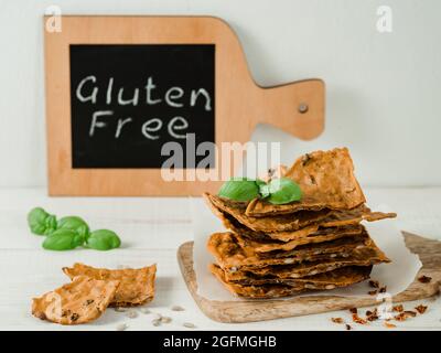 Glutenfreie Knäckebrot aus Buskweizenmehl. Grünes Buchweizenmehl, geräucherter Paprika und Sonnenblumenkerne sind Zutaten für dieses hausgemachte, knusprige Brot. Idea Rezept Snacks, glutenfreies Konzept Stockfoto