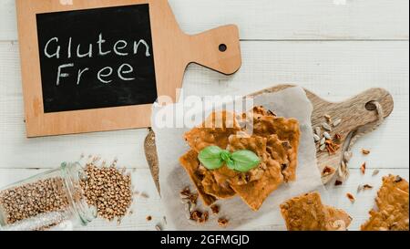 Glutenfreie Knäckebrot aus Buskweizenmehl. Grünes Buchweizenmehl geräuchertes Paprika Sonnenblumenkerne Zutaten hausgemachtes, gebackenes Knäckebrot. Idee Rezept Snacks glutenfreies Konzept. Draufsicht flach liegend Stockfoto