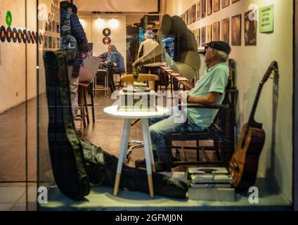 HONGKONG, HONGKONG - 24. Jul 2018: Ein Fensterblick auf einen Mann, der in einem alten Plattenladen in Hongkong Musik hört Stockfoto