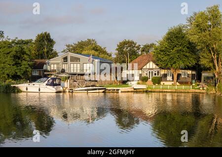 Boote und Häuser liegen am Ufer der themse bei Laleham in surrey Stockfoto