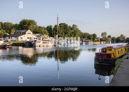 Boote und Häuser liegen am Ufer der themse bei Laleham in surrey Stockfoto