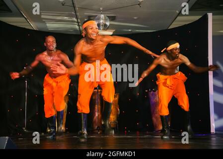 JOHANNESBURG, SÜDAFRIKA - 03. Mai 2019: Traditionelle afrikanische Tänzer mit Gummistiefeln und orangefarbenen Hosen Stockfoto
