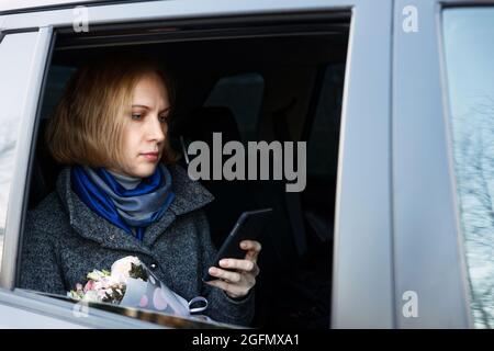 Porträt einer Frau, die Smartphone im Auto verwendet Stockfoto