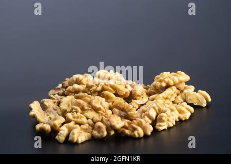 Walnüsse in zwei Hälften auf schwarzem Hintergrund Stockfoto