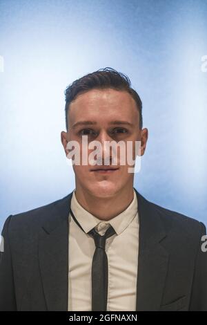 Formelles Nahaufnahme-Porträt eines jungen hübschen kaukasischen Geschäftsmanns in elegantem Business-Anzug mit Krawatte. Foto der Dokumente Stockfoto