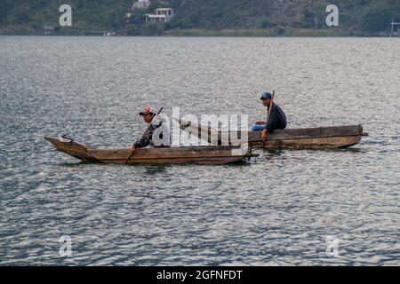 SANTIAGO ATITLAN, GUATEMALA - 23. MÄRZ 2016: Fischer auf traditionellen Holzbooten auf dem Atitlan See in der Nähe des Dorfes Santiago Atitlan. Stockfoto