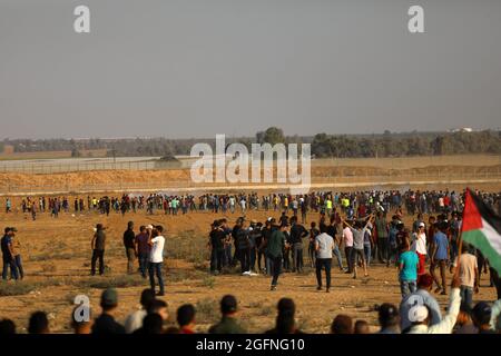 Gaza-Streifen. August 2021. Palästinensische Demonstranten laufen von Tränengas, das von israelischen Sicherheitskräften während eines Protestes entlang des Grenzzauns östlich von Khan Yunis im südlichen Gazastreifen abgefeuert wurde, um die israelische Blockade des palästinensischen Sektors anzuprangern. Stockfoto