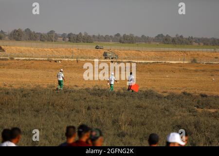 Gaza-Streifen. August 2021. Palästinensische Demonstranten laufen von Tränengas, das von israelischen Sicherheitskräften während eines Protestes entlang des Grenzzauns östlich von Khan Yunis im südlichen Gazastreifen abgefeuert wurde, um die israelische Blockade des palästinensischen Sektors anzuprangern. Stockfoto