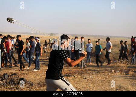 Gaza-Streifen. August 2021. Palästinensische Demonstranten laufen von Tränengas, das von israelischen Sicherheitskräften während eines Protestes entlang des Grenzzauns östlich von Khan Yunis im südlichen Gazastreifen abgefeuert wurde, um die israelische Blockade des palästinensischen Sektors anzuprangern. Stockfoto