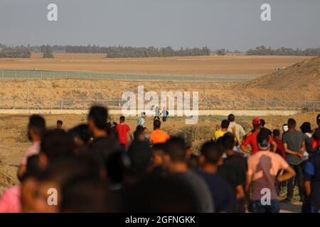 Gaza-Streifen. August 2021. Palästinensische Demonstranten laufen von Tränengas, das von israelischen Sicherheitskräften während eines Protestes entlang des Grenzzauns östlich von Khan Yunis im südlichen Gazastreifen abgefeuert wurde, um die israelische Blockade des palästinensischen Sektors anzuprangern. Stockfoto