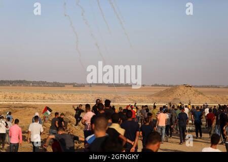 Gaza-Streifen. August 2021. Palästinensische Demonstranten laufen von Tränengas, das von israelischen Sicherheitskräften während eines Protestes entlang des Grenzzauns östlich von Khan Yunis im südlichen Gazastreifen abgefeuert wurde, um die israelische Blockade des palästinensischen Sektors anzuprangern. Stockfoto
