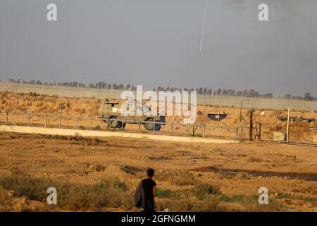 Gaza-Streifen. August 2021. Palästinensische Demonstranten laufen von Tränengas, das von israelischen Sicherheitskräften während eines Protestes entlang des Grenzzauns östlich von Khan Yunis im südlichen Gazastreifen abgefeuert wurde, um die israelische Blockade des palästinensischen Sektors anzuprangern. Stockfoto