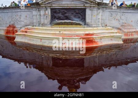 London, Großbritannien. August 2021. Tieraufstand-Aktivisten füllten und bedeckten die Brunnen am Victoria Memorial vor dem Buckingham Palace mit gefälschtem Blut, um gegen die Nutzung des riesigen Landes durch die königliche Familie für die Tierzucht und Jagd zu protestieren. (Kredit: Vuk Valcic / Alamy Live News) Stockfoto
