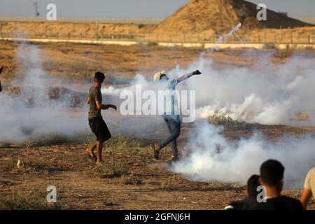 Gaza-Streifen. August 2021. Palästinensische Demonstranten laufen von Tränengas, das von israelischen Sicherheitskräften während eines Protestes entlang des Grenzzauns östlich von Khan Yunis im südlichen Gazastreifen abgefeuert wurde, um die israelische Blockade des palästinensischen Sektors anzuprangern. Stockfoto